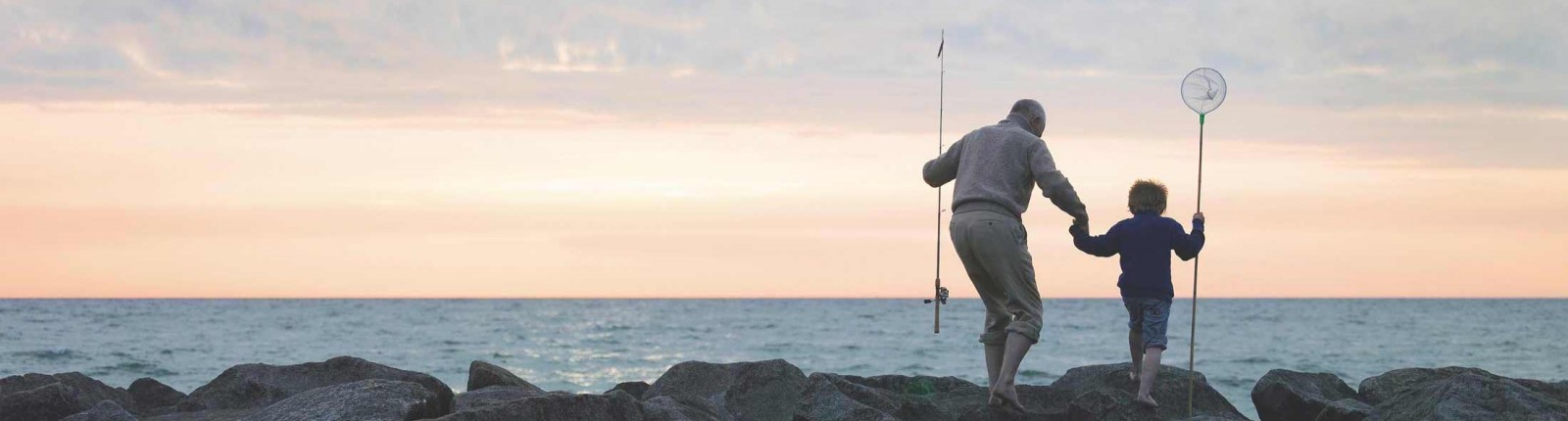 Man and boy fishing by the sea