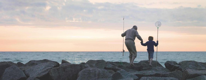 Man and boy fishing by the sea